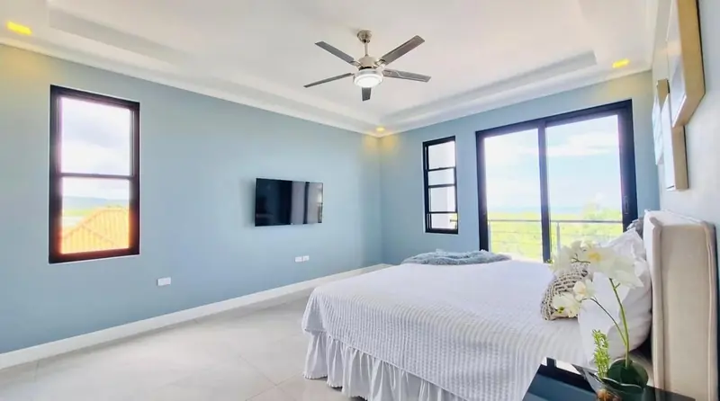 Primary bedroom with a sliding door to the balcony and the sea beyond