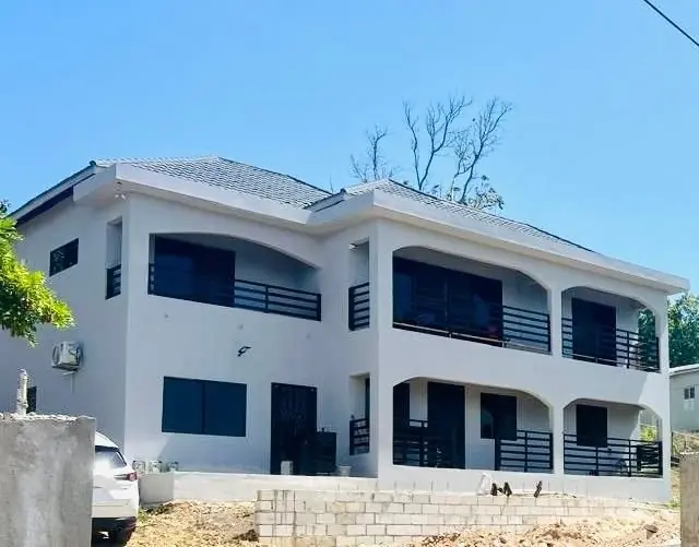 Two-storey white house in Huddersfield with dark balcony rails on both floors