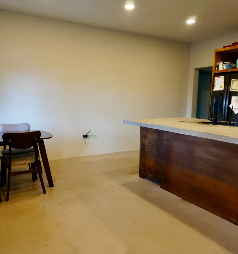 Kitchen island in dark timber with a dining table beside it